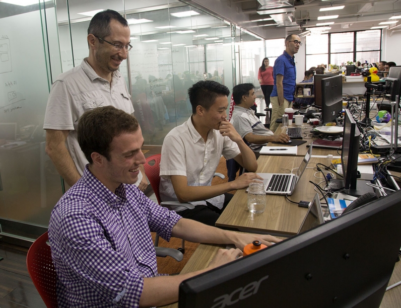 Princeton juniors Raoul Rodriguez and Daniel Liu (seated left to right in foreground) work with Boris Boroda (standing), vice president of engineering at AbilTo.