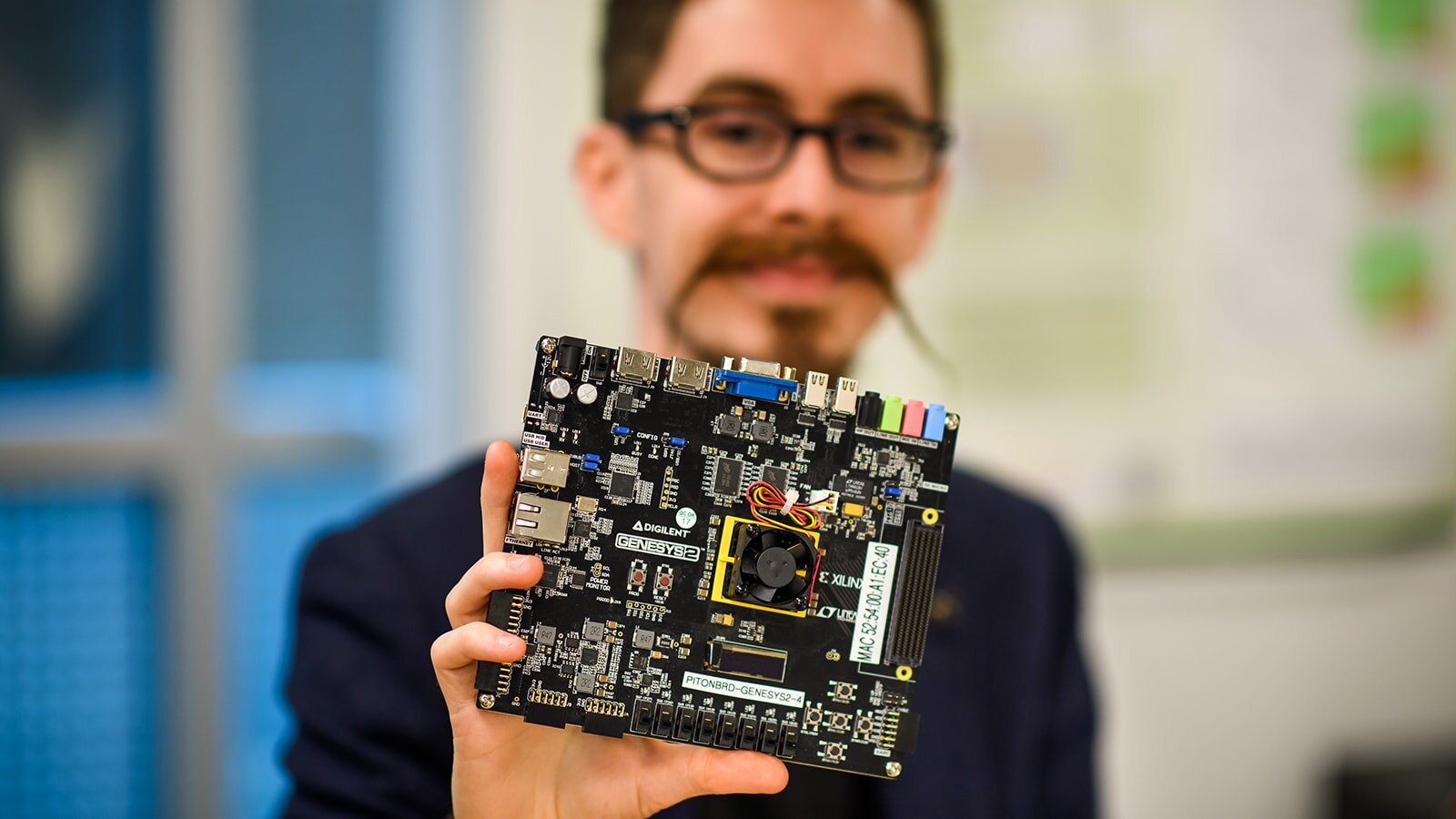 Jonathan Balkind holding a piece of computer equipment close to the viewer.